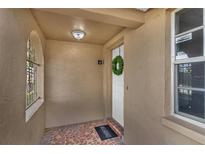 Covered front porch with tiled flooring and decorative window at 9430 Glen Moor Ln, Port Richey, FL 34668