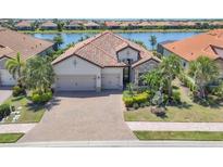 Beautiful single-Gathering home with well manicured landscaping and a three-car garage located on a body of water at 7036 Highgate Ln, Lakewood Ranch, FL 34202