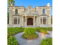 Elegant home with a columned entryway, balcony, and lush landscaping at 1577 Alexander Rd, Belleair, FL 33756