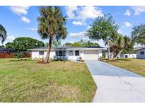 Charming single-story home featuring a well-manicured lawn and beautiful palm trees in a sunny neighborhood at 2005 47Th Street W Ct, Bradenton, FL 34209