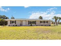Charming single-story home featuring a well-manicured lawn, neutral paint and black shutters at 219 Marlin Dr, Punta Gorda, FL 33950