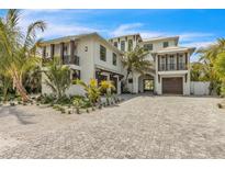 Stunning two-story home with private balconies, lush tropical landscaping, and a beautiful paved driveway at 224 Chilson Ave, Anna Maria, FL 34216