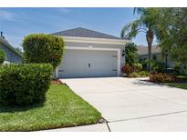 Well-maintained two-car garage with a concrete driveway and attractive landscaping at 4318 Deep Creek Ter, Parrish, FL 34219