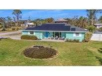 Inviting single-story home featuring solar panels, a well-manicured lawn, and comfortable outdoor seating at 4440 Yacht Club Dr, Venice, FL 34293