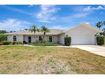 Charming home featuring a two-car garage, lush landscaping, and a welcoming front entrance at 519 Bayview Ave, Osprey, FL 34229