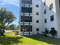 Low-rise condo building featuring white balconies and green lawn at 5970 80Th N St # 101, St Petersburg, FL 33709