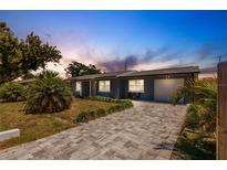 Charming single-story home with a well-manicured lawn and brick driveway at 6009 Lords Ave, Sarasota, FL 34231