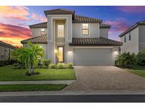 Beautiful two-story home with a tile roof, manicured lawn, and brick paved driveway at 6535 Clairborne Ln, Bradenton, FL 34211