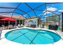 Sparkling pool with screened-in enclosure, surrounded by outdoor seating and lush landscaping at 7814 48Th E Ave, Bradenton, FL 34203