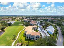 Scenic aerial view of the community featuring lush green landscaping, pond, and well-maintained condominium buildings at 9630 Club South Cir # 6201, Sarasota, FL 34238