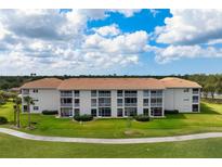 Beautiful condo building featuring a red tile roof, screened balconies, and well-maintained landscaping at 9630 Club South Cir # 6201, Sarasota, FL 34238