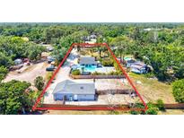 Aerial view of home on large lot with inground pool, studio, and fenced yard at 1518 Stoeber Ave, Sarasota, FL 34232