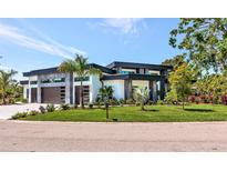 Modern home showcasing stylish architectural details, well-maintained landscaping, and a lush green lawn at 1555 Eastbrook Dr, Sarasota, FL 34231