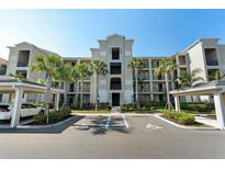 Condominium complex with light gray exterior, palm trees, covered parking, and handicap parking spaces at 17902 Gawthrop Dr # 107, Bradenton, FL 34211