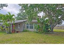 Charming single-story home featuring a bright green door, complemented by lush landscaping and mature trees at 2906 Arlington St, Sarasota, FL 34239