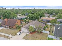 An aerial view of a single Gathering home featuring mature trees, a two car garage and a white vehicle parked in the driveway at 4053 Lancaster Dr, Sarasota, FL 34241