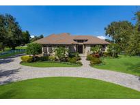 Stunning home with lush landscaping, circular driveway, and classic architecture on a sunny day at 4610 13Th W St, Palmetto, FL 34221