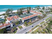 Aerial view showcasing a coastal community with tennis courts and beachfront access near Gulf of Mexico at 5055 Gulf Of Mexico Dr # 414, Longboat Key, FL 34228