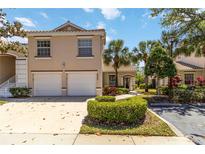 Charming two-story townhome featuring a two-car garage, tile roof, and well-manicured landscaping at 6339 Bay Cedar Ln # 102, Bradenton, FL 34203