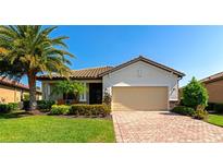 Beautiful single-story home with lush landscaping, brick driveway, and a two-car garage at 6524 Willowshire Way, Bradenton, FL 34212