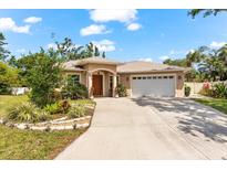 Charming single-story home featuring a two-car garage, arched entry, and lush landscaping at 9146 16Th Avenue Nw Cir, Bradenton, FL 34209