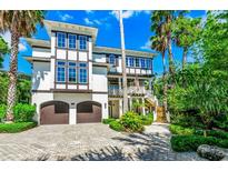 Stunning home with two-car garage, second-story balcony, and mature landscaping at 103 Park Ave, Anna Maria, FL 34216
