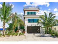 Stunning contemporary home with a rooftop deck, lush tropical landscaping, and an attached two-car garage at 135 Grant Dr, Sarasota, FL 34236