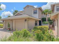 Beautiful exterior of a two-story home with a well-manicured lawn, attached garage, and tiled front walk at 1612 Starling Dr # 101, Sarasota, FL 34231