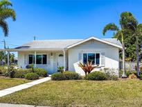 Charming single-story home featuring a well-manicured lawn and lush landscaping, creating inviting curb appeal at 214 49Th W St, Bradenton, FL 34209