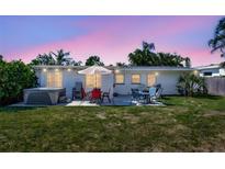 Backyard patio with hot tub, dining table, and grill, perfect for outdoor entertaining at 2307 Valencia Dr, Sarasota, FL 34239