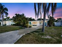 This home features a long drive, clean white exterior, and lush landscaping at 2307 Valencia Dr, Sarasota, FL 34239