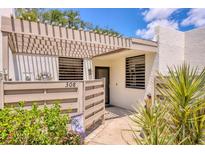 Inviting condo entrance with a pergola, privacy fence, and lush landscaping at 308 Timber Lake Dr, Bradenton, FL 34210