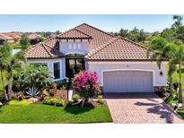 Beautiful single-story home showcasing a tile roof, manicured lawn and lush landscaping at 5437 Manchini St, Sarasota, FL 34238