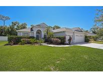 Charming single Gathering home featuring a lush green lawn and a two-car garage with an ample drive way at 7390 Deer Crossing Ct, Sarasota, FL 34240