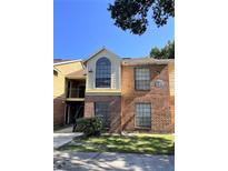 Two-story condo unit with brick facade, green grass and updated windows in well-maintained community at 8617 Fancy Finch Dr # 102, Tampa, FL 33614