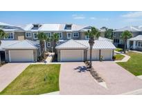 Beautiful townhome exterior with metal roof, paver driveway and tropical landscaping at 10720 Lemon Creek Loop # 103, Englewood, FL 34224