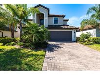 Charming two-story home with a paved driveway and a two-car garage, surrounded by lush landscaping at 11510 Sweetgrass Dr, Bradenton, FL 34212
