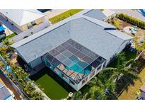Aerial view of a home featuring a screened-in pool area, spacious yard, and lush tropical landscaping at 1724 Cheyenne St, Sarasota, FL 34231