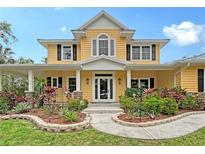 Charming two-story yellow home featuring a landscaped front yard, covered porch, and inviting entrance at 1788 Palm View Rd, Sarasota, FL 34240