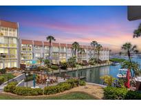 Waterfront condo with boat docks, palm trees, and inviting outdoor seating areas at 210 Santa Maria St # 244, Venice, FL 34285