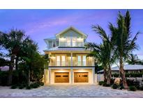 Beautiful two-story home boasts two balconies, a garage, and lush landscaping in a vibrant tropical setting at 221 Grant Dr, Sarasota, FL 34236