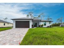 Beautiful single-Gathering home with paver driveway and lush green lawn at 2231 Hagoplan Ln, North Port, FL 34288