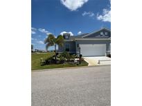 Charming single-story home with well-manicured lawn and a two-car garage in a quiet neighborhood at 24835 Buckingham Way, Port Charlotte, FL 33980