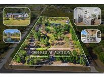 Expansive aerial view of property offered at auction featuring lush greenery, pond, house, outdoor living, and modern kitchen at 25305 83Rd E Ave, Myakka City, FL 34251