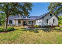 Charming single-Gathering home features a metal roof, white siding, and a well-manicured lawn at 25305 83Rd E Ave, Myakka City, FL 34251