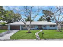 Charming one story home with beautiful yard, light blue exterior, and mature trees at 2932 Upper Tangelo Dr, Sarasota, FL 34239