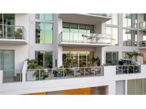 Relaxing balcony with sleek glass railings and stylish furniture, perfect for enjoying outdoor living at 301 Quay Commons # 503, Sarasota, FL 34236