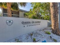 The Oasis on Osprey condominium community sign with lush trees at 3350 S Osprey Ave # 211A, Sarasota, FL 34239