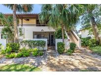 Exterior front view of a two-story home with a private gated courtyard entrance and lush greenery around the entryway at 3500 El Conquistador Pkwy # 117, Bradenton, FL 34210
