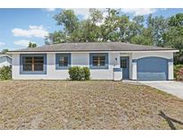 Charming single-story home with blue trim, attached garage, and a cozy front yard at 5414 Ansonia Ter, North Port, FL 34287